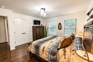 A bedroom with a bed, a wardrobe, a television, and a window with blinds. - The Fawn Château w/ Game Room & sauna  (Lake Ariel)