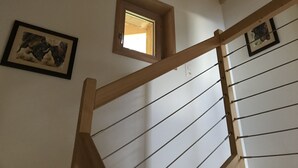 A wooden staircase with a small window and framed artwork on the wall. - Chez FOLLO Formidable Mayen in old wood (Mase)