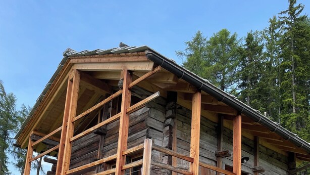 A log cabin with a stone foundation, wooden balcony, and a stone wall surrounding the property. - Chez FOLLO Formidable Mayen in old wood (Mase)