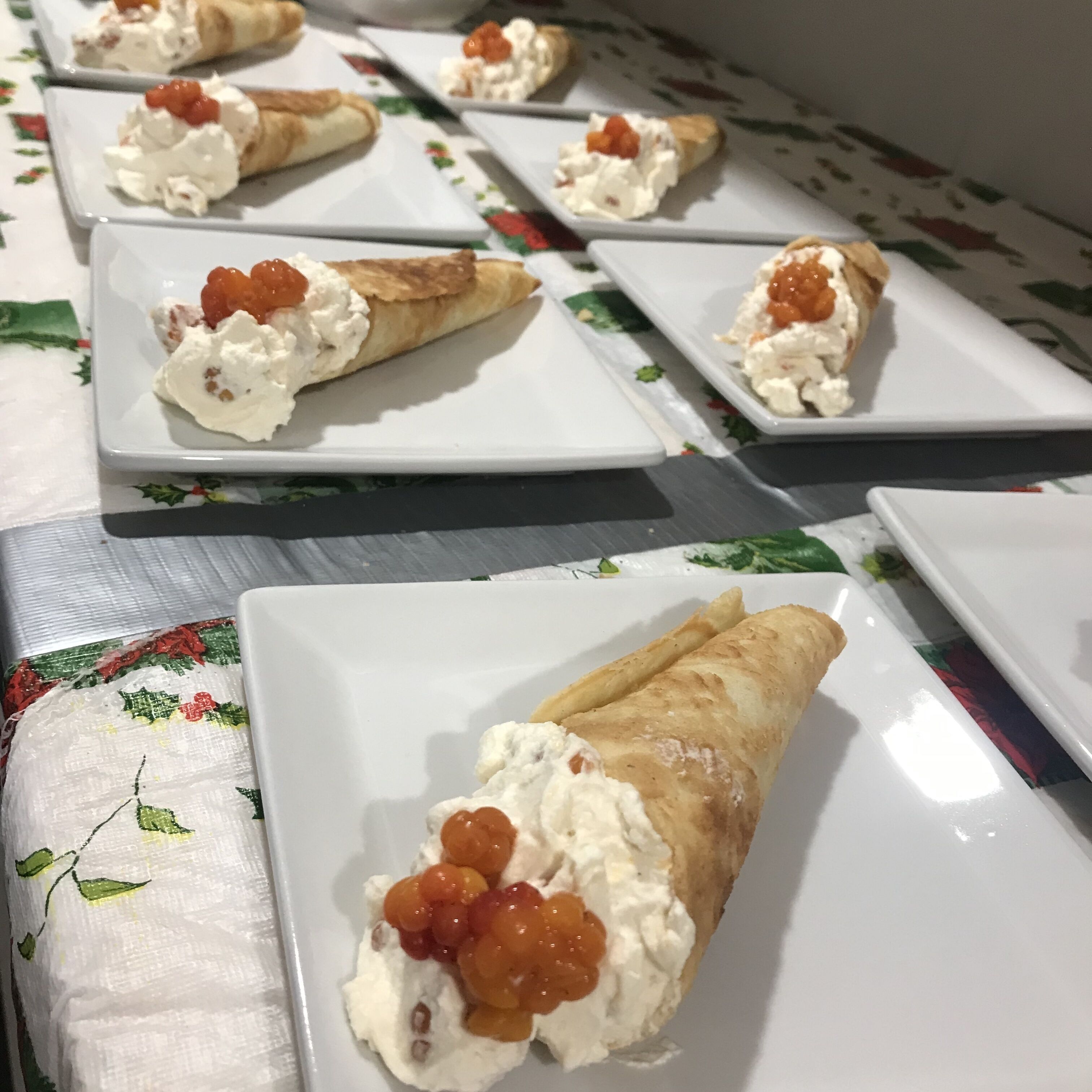 A table with several plates of pastry cones topped with cream and caviar.