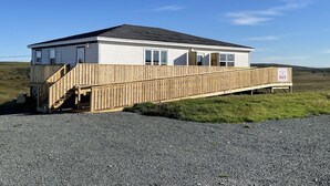A single-story building with a wooden deck and a ramp leading to the entrance.
