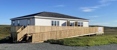 A single-story building with a wooden deck and a ramp leading to the entrance.