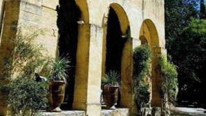 A building with a stone facade, multiple arches, and tall trees. - Le Nid Castries - Wonderful privated place fully equipped  (Castries)