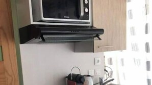 A compact kitchen with a microwave, a small sink, and a compact refrigerator. - Le Nid Castries - Wonderful privated place fully equipped  (Castries)