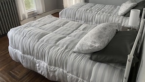A bedroom with two beds, a radiator, and a window with curtains. - Finger Lakes Escape: Spacious 5-Bedroom Home in Canandaigua (Canandaigua)