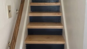A staircase with wooden steps and a wooden handrail. - Finger Lakes Escape: Spacious 5-Bedroom Home in Canandaigua (Canandaigua)
