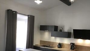 Moderni keittiö, jossa on ruokailutila, sohva ja pöytä.
