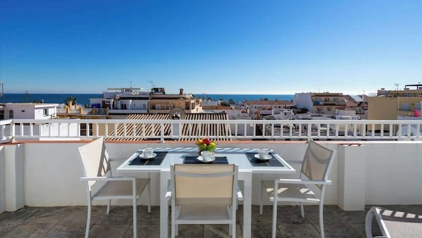 A terrace with a table and chairs, overlooking a coastal cityscape. - Pool Penthouse in La Cala by Costarentals - Ref 19 (Las Lagunas de Mijas)