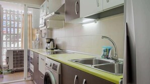 Una cocina compacta con lavadora, lavavajillas y microondas.