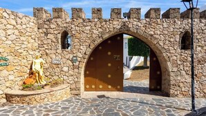 A stone archway leading to a building with a brown door, a statue, and a sign that reads "PATRIO COLE". - Villa Sabah with sea views near Mijas Pueblo - REF 119 (Mijas)