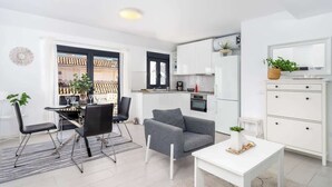 A modern apartment with a dining area, a gray sofa, a kitchen, and a white dresser. - Beachclose Penthouse by Costarentals - Ref 15 (Fuengirola)