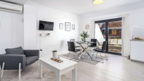 A modern living room with a white sofa, a coffee table, and a dining area with a glass table and chairs. - Beachclose Penthouse by Costarentals - Ref 15 (Fuengirola)