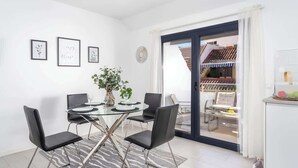 A modern dining area with a glass table and black chairs, a potted plant, and framed artwork on the wall. - Beachclose Penthouse by Costarentals - Ref 15 (Fuengirola)
