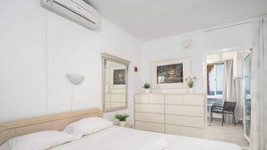 A hotel room with a bed, a dresser, a mirror, and a view of the balcony. - Benalmádena with sauna by Costarentals - Ref 72 (Benalmádena)
