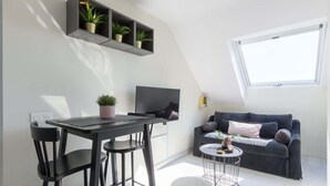 A modern, compact living space with a dining area, a sofa, and a TV. - Modern sea view rooftop by Costarentals - Ref 116 (Fuengirola)