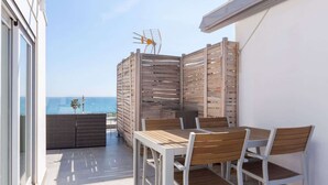 A balcony with a table and chairs, a wooden fence, and a view of the sea. - Modern sea view rooftop by Costarentals - Ref 116 (Fuengirola)