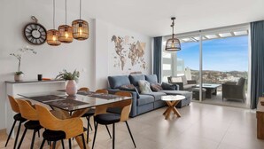 Un salon moderne comprenant un coin repas, un ensemble de canapés et une carte du monde accrochée au mur.