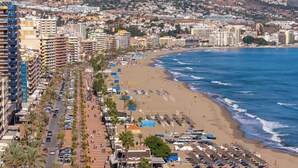 A coastal cityscape with a beach, a long promenade lined with palm trees, and buildings along the waterfront. - Beachfront Stella Maris by Costarentals - Ref 36 (Fuengirola)