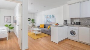 A compact apartment with a kitchenette, a sofa, a dining area, and a washing machine. - Central couples getaway by Costarentals - Ref 155 (Fuengirola)