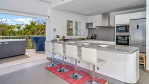 A modern kitchen with a central island, stainless steel appliances, and a view of the outdoors. - Sunny Terrace with Jacuzzi by Costarentals- Ref 26 (Benalmádena)