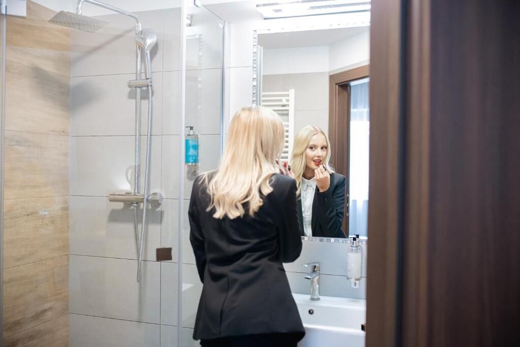 Un baño moderno con ducha de vidrio, lavamanos y espejo.