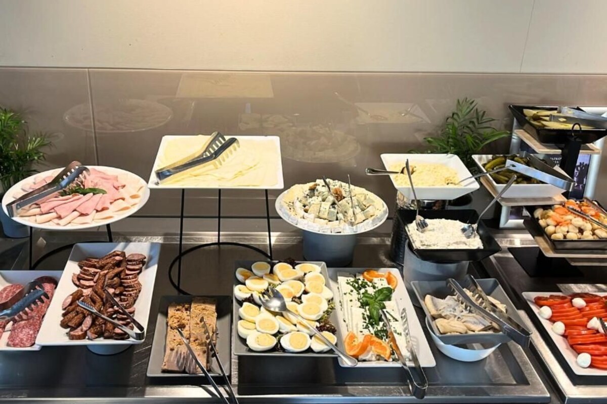 Un bufé con diferentes opciones de comida, como carnes, quesos y verduras.