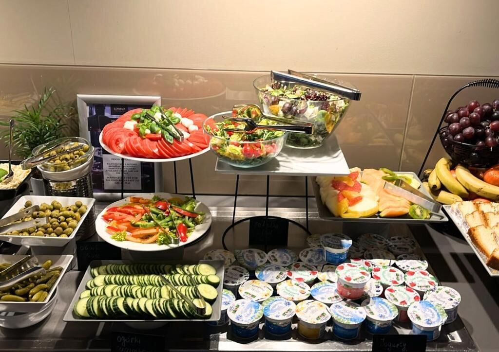 A buffet with various food items including salads, fruits, and yogurt.