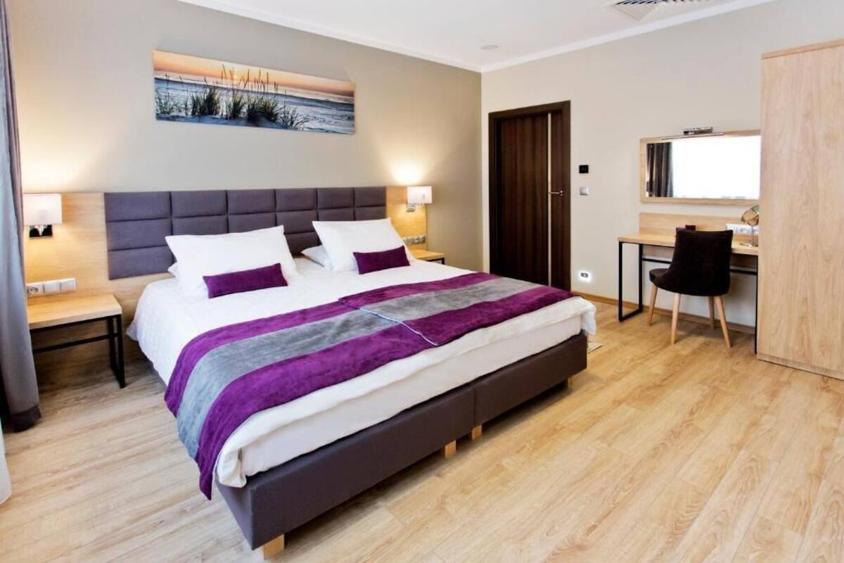 Quarto de hotel moderno com uma cama grande, uma escrivaninha e uma cadeira.