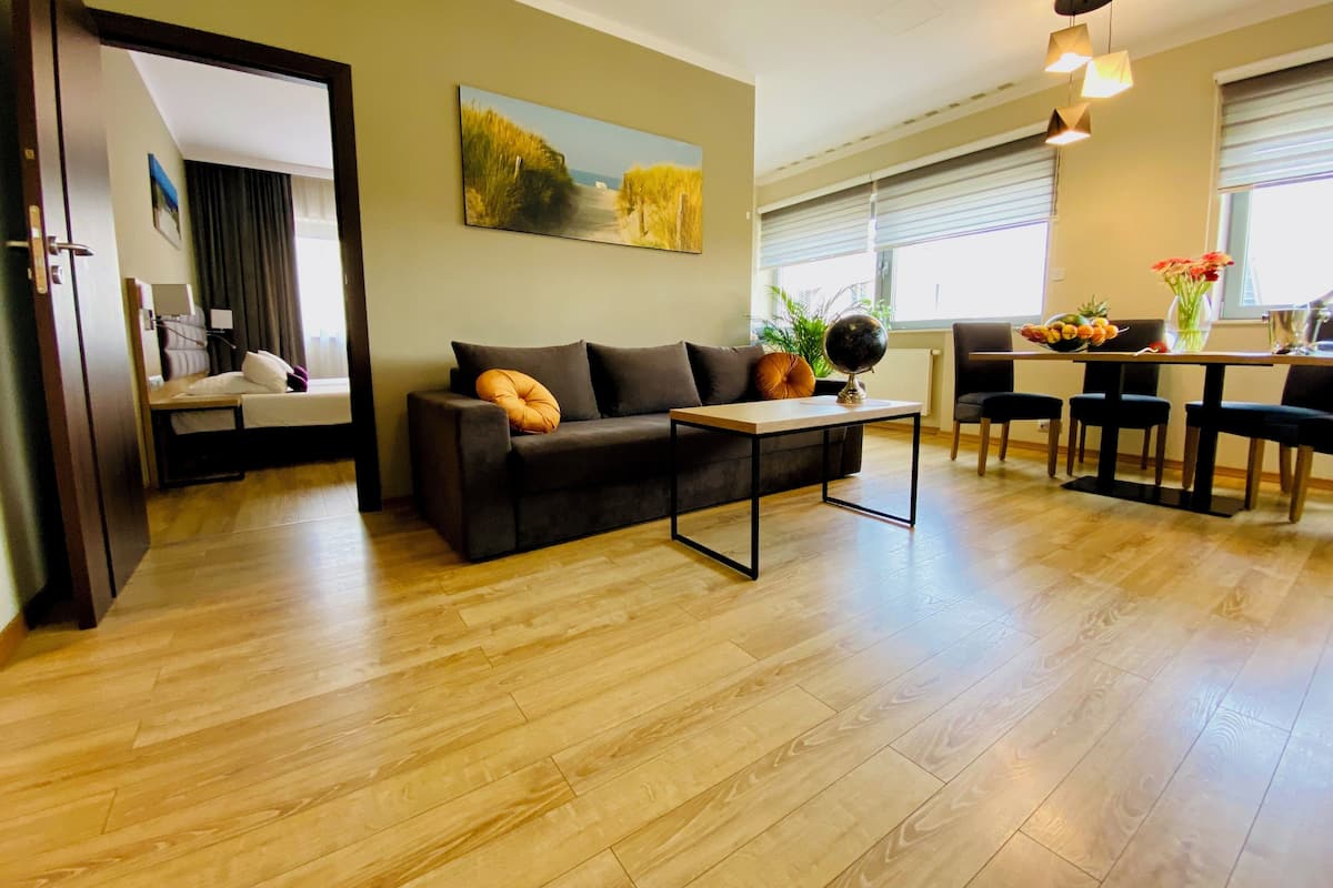 Uma sala de estar moderna com sofá, mesa de centro e um quadro na parede.