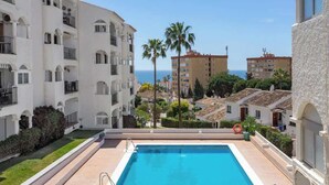 A swimming pool with a clear view of the sea and surrounding buildings.