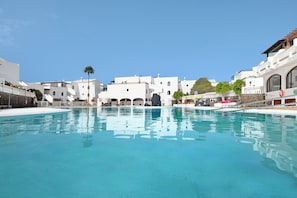 Ein Swimmingpool mit weißen Gebäuden im Hintergrund.