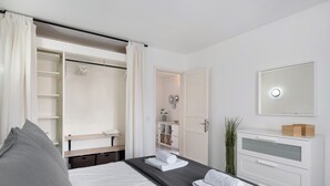 Une chambre d’hôtel comprenant un lit, une armoire, un miroir et une table de chevet.