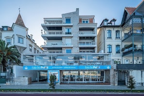 Un immeuble à plusieurs étages qui abrite un restaurant appelé « Baía do Peixe » au rez-de-chaussée.