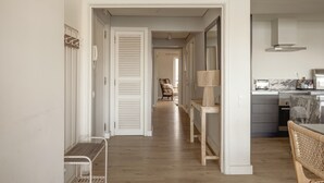 Un couloir menant à une cuisine comprenant un coin repas, une chaise et une table.