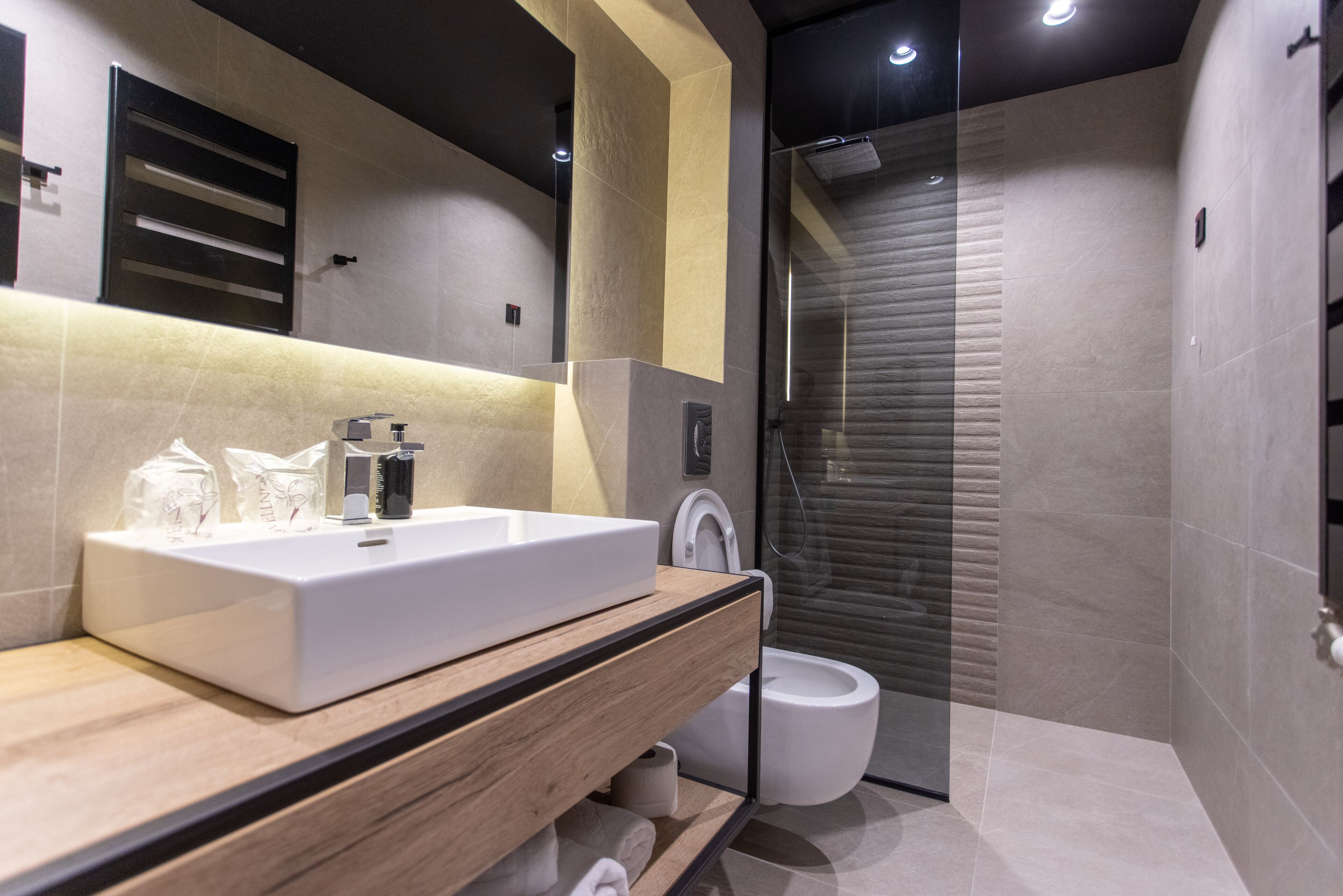 Un baño moderno con un lavamanos grande, inodoro y ducha.