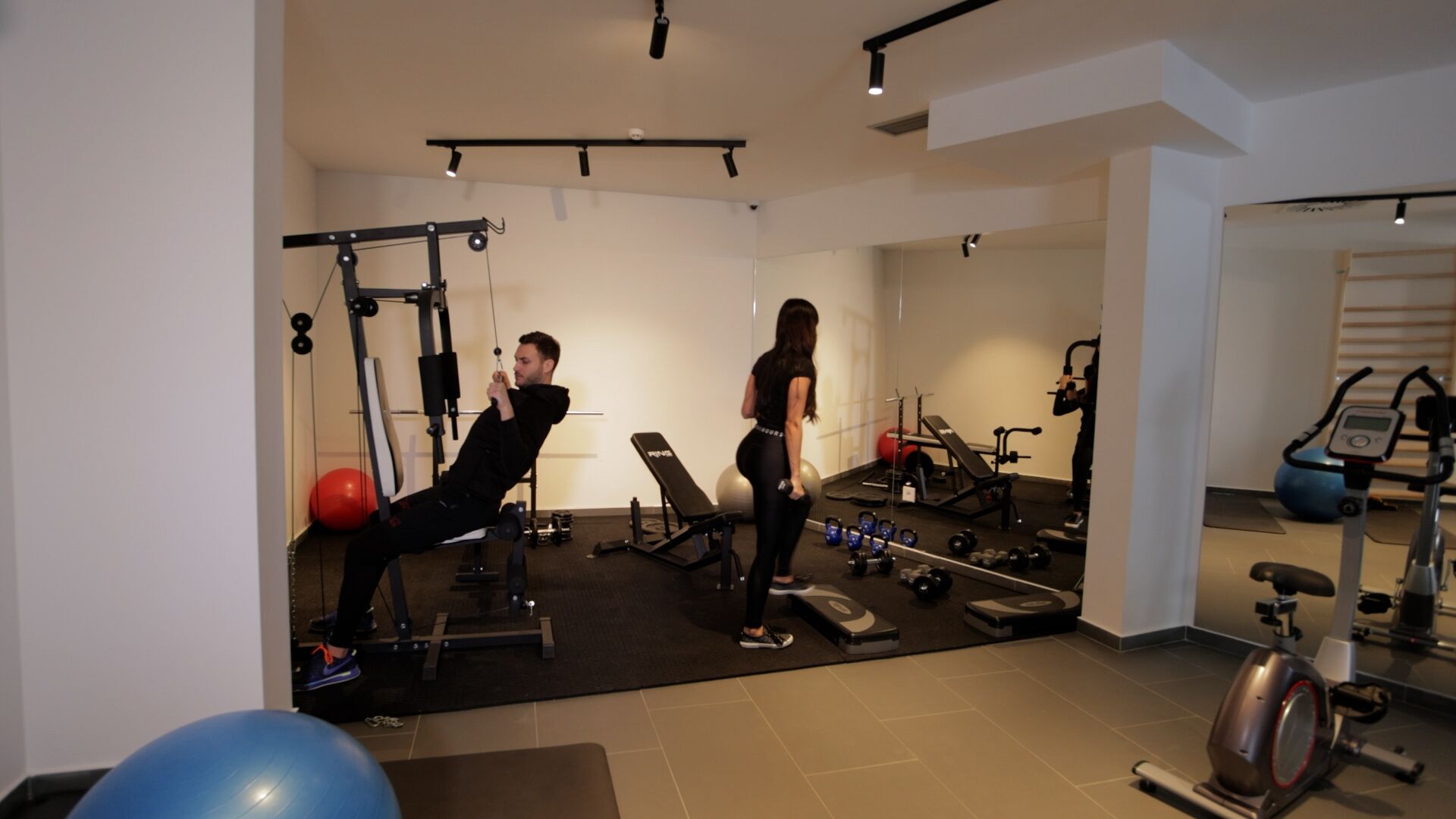 Una palestra con attrezzature per esercizi, una panca e pesi.