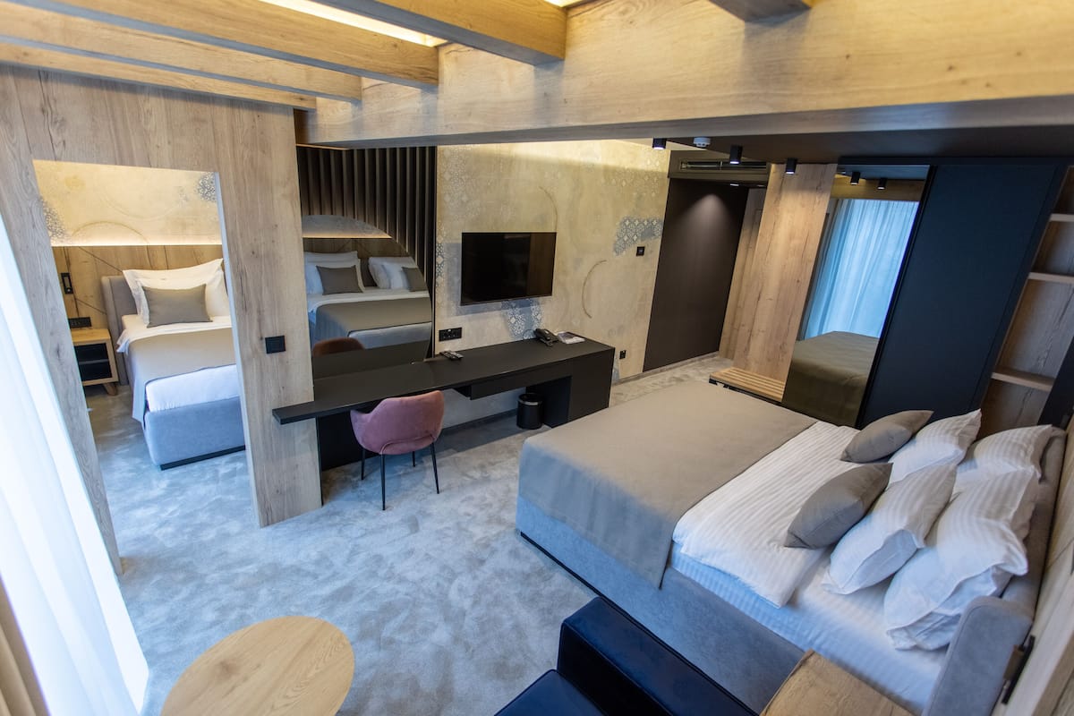 A modern bedroom with a bed, desk, and seating area.