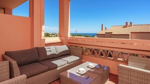 Un balcon avec un canapé, des chaises et une table.