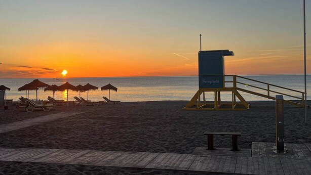 A lifeguard tower labeled "Fuengirola" on a beach with lounge chairs and umbrellas.