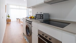 A modern kitchen with a built-in washing machine, microwave, and oven. - HomeForGuest Studio Sol Canteras with terrace  (Las Palmas de Gran Canaria)