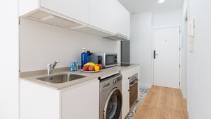 A compact kitchen with a washing machine, a microwave, and a sink. - HomeForGuest Studio Sol Canteras with terrace  (Las Palmas de Gran Canaria)