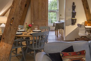 Un coin repas accueillant avec une table en bois, des chaises et un vase de fleurs.