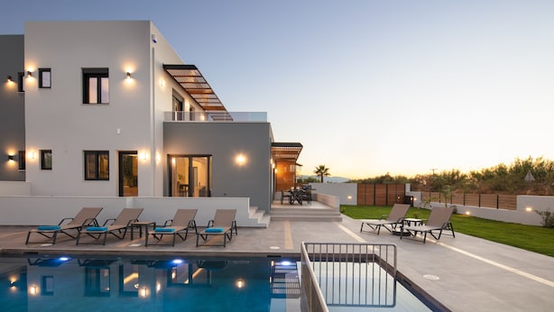 A modern poolside area with lounge chairs and a pool.
