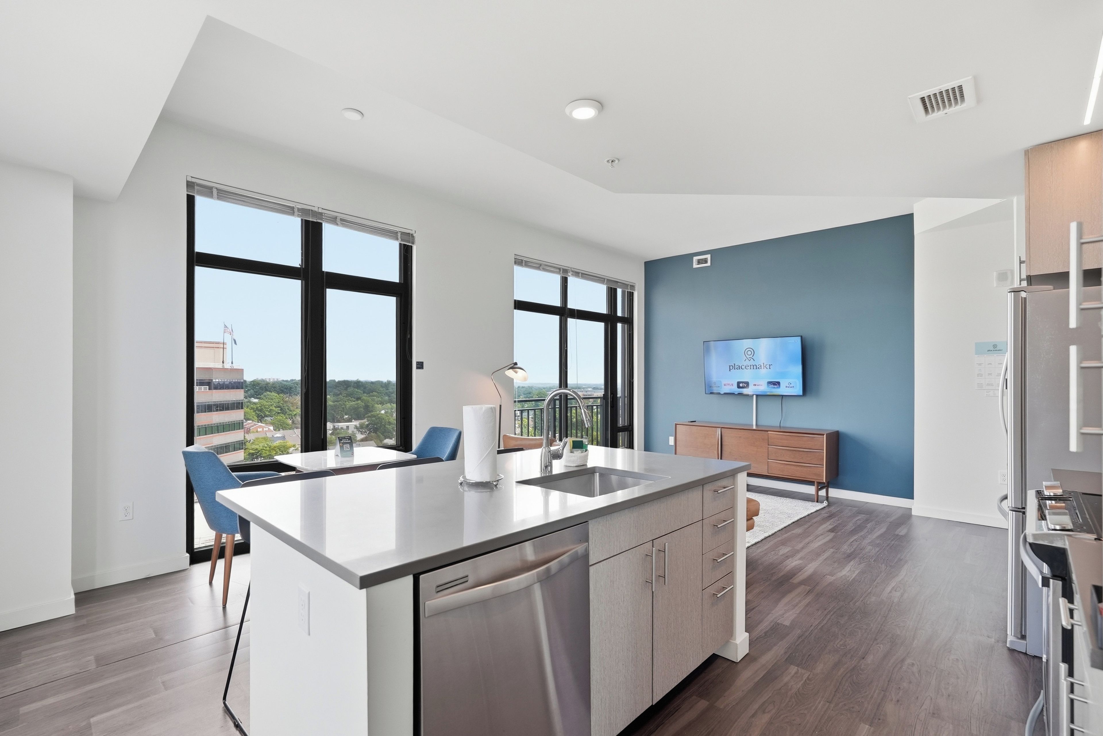 A modern kitchen with a dishwasher, a large island, and a built-in oven.