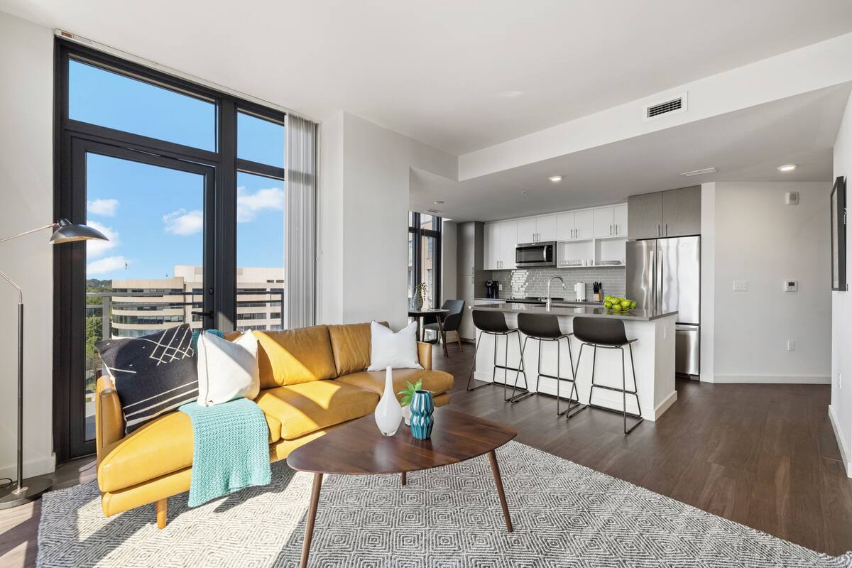 A modern apartment with a living room, kitchen, and dining area.