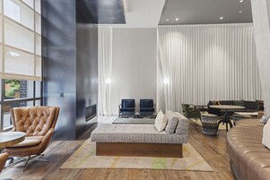 Una sala de estar moderna con un sofá, sillones, una mesa de centro y una chimenea.
