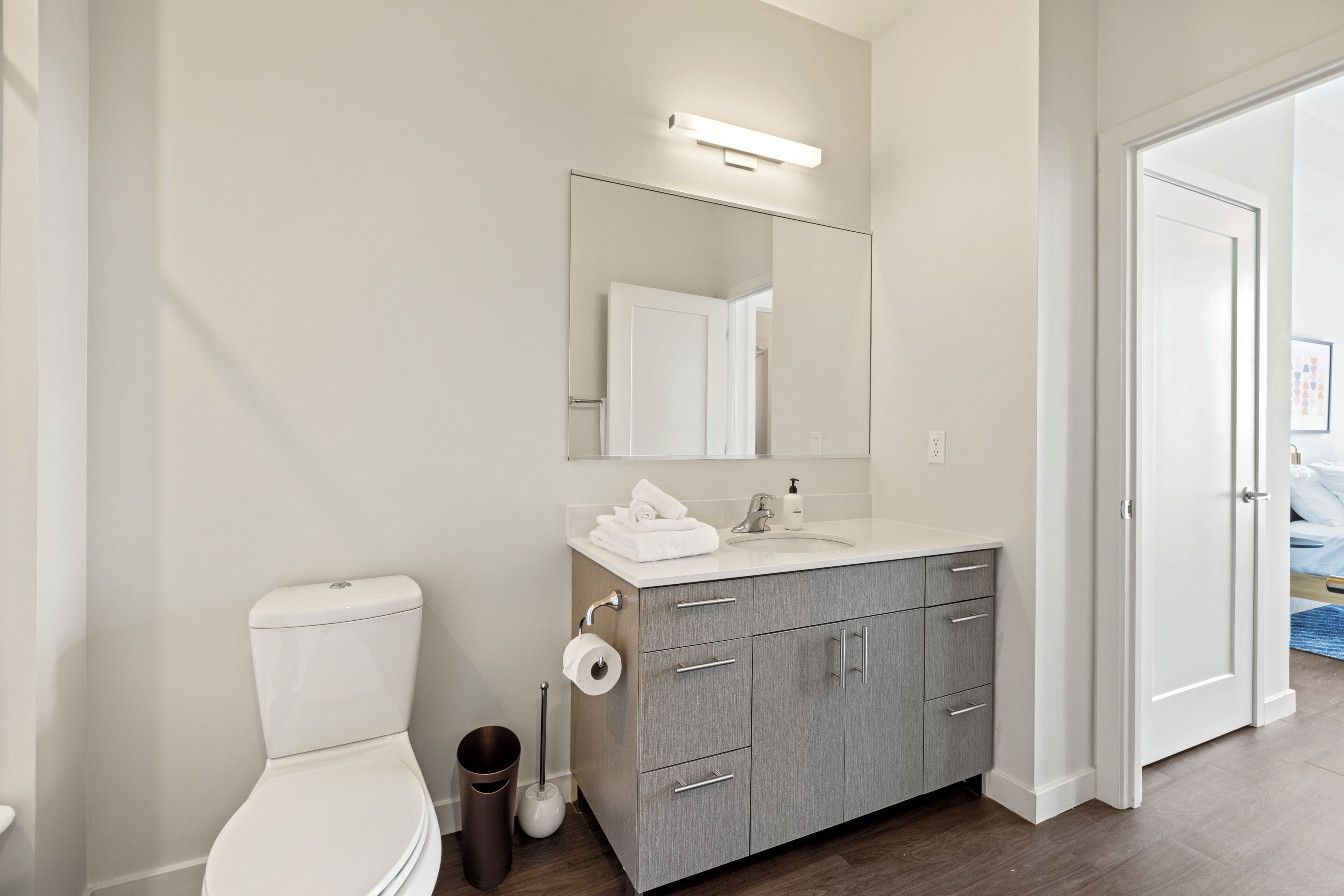 A modern bathroom with a toilet, sink, and vanity.