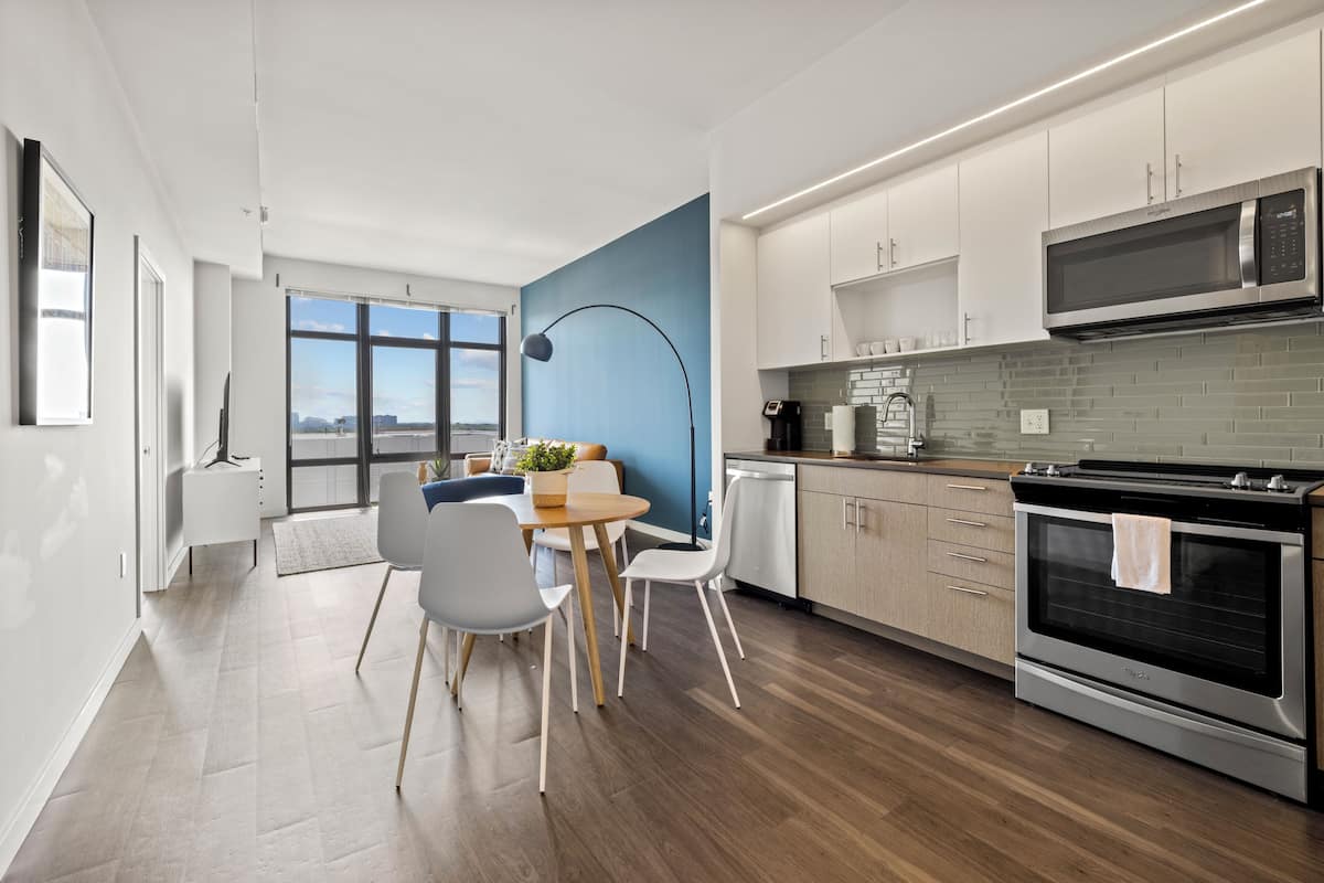 A modern kitchen with white cabinets, a built-in microwave, and a large oven.