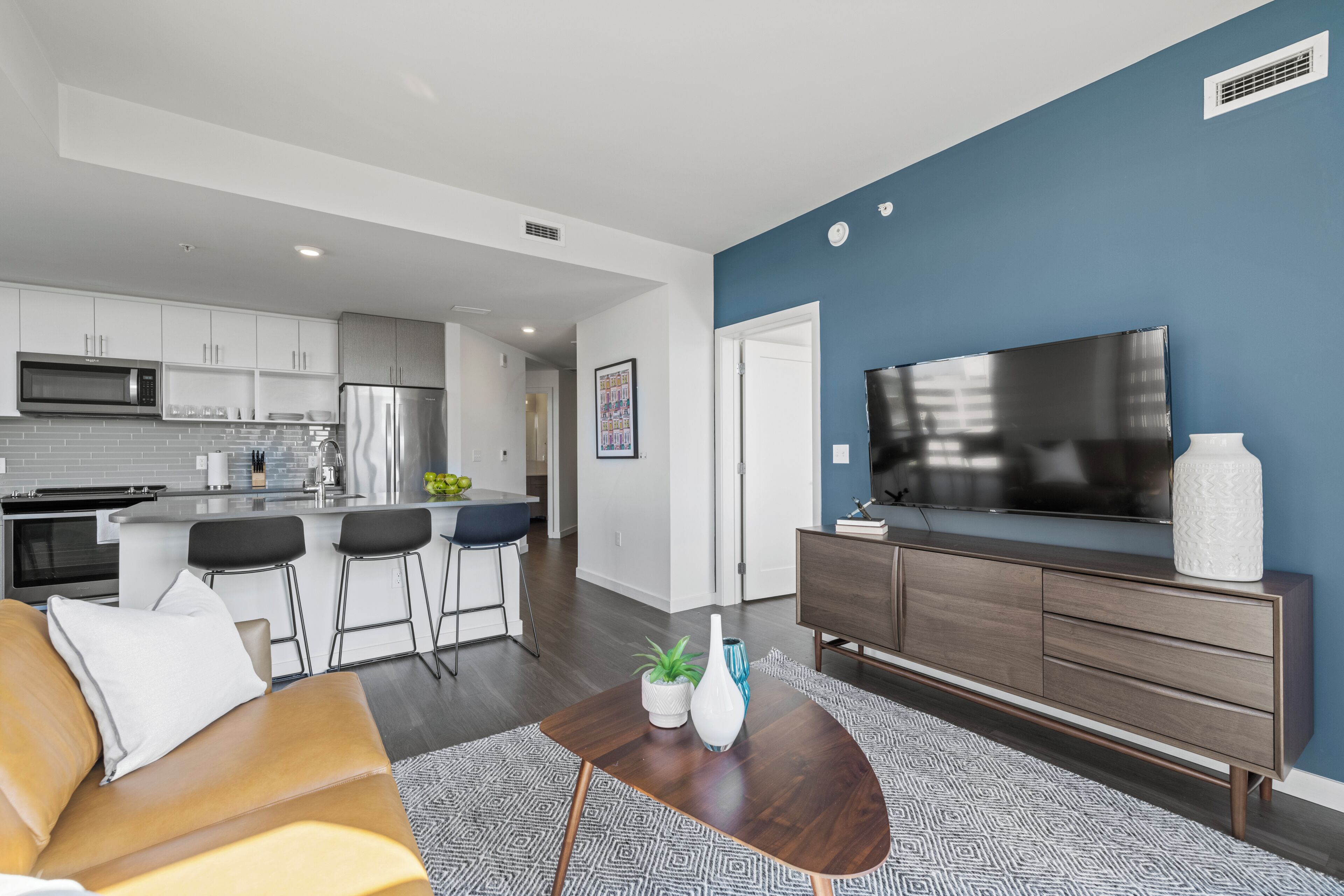 A modern living room with a sofa, coffee table, and a TV on a stand.