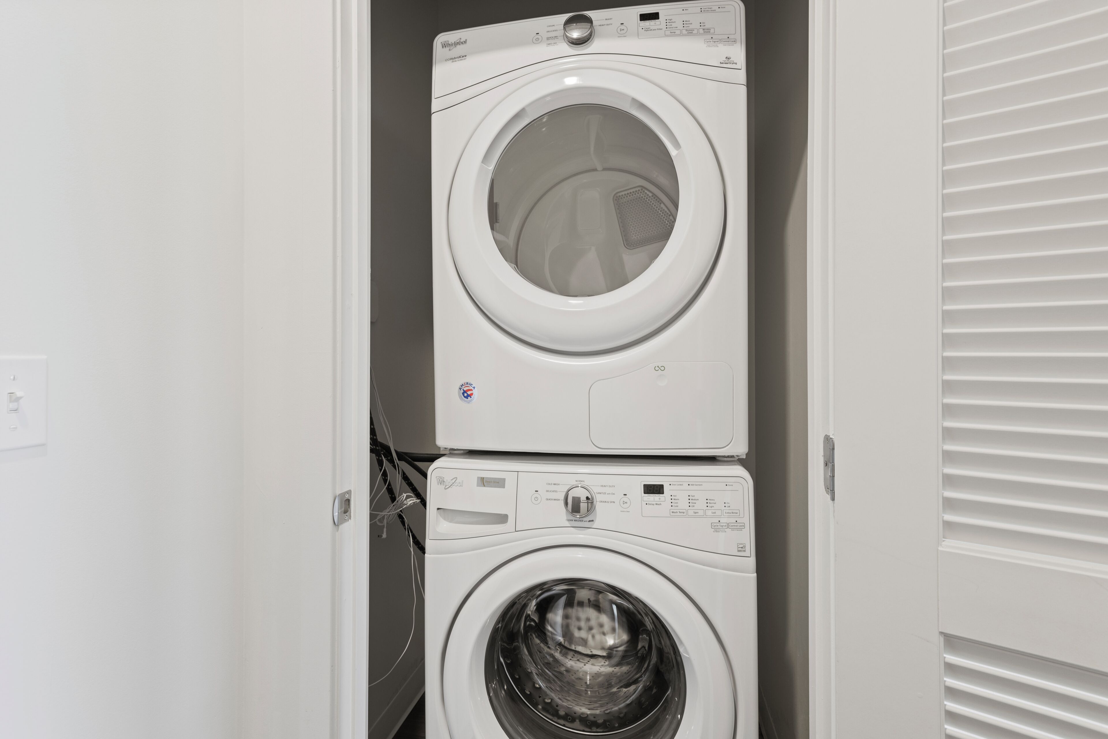 A stacked washer and dryer unit in a laundry room.